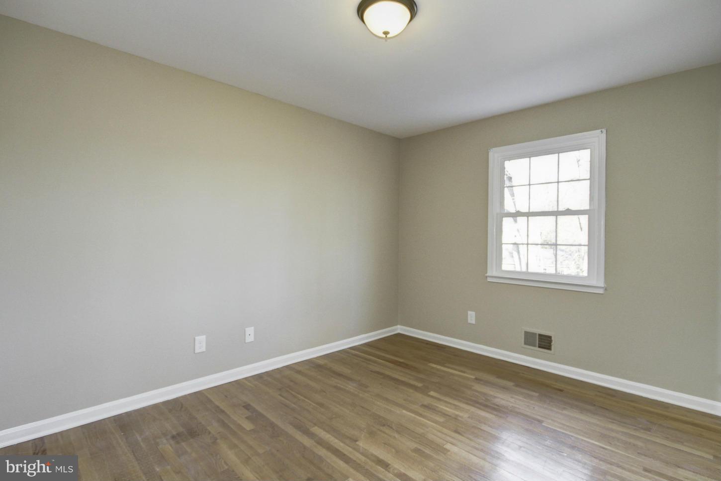 12208 St James Road Potomac, MD 20854 - Photo 16 of 29 wooden floor in an empty room with a window