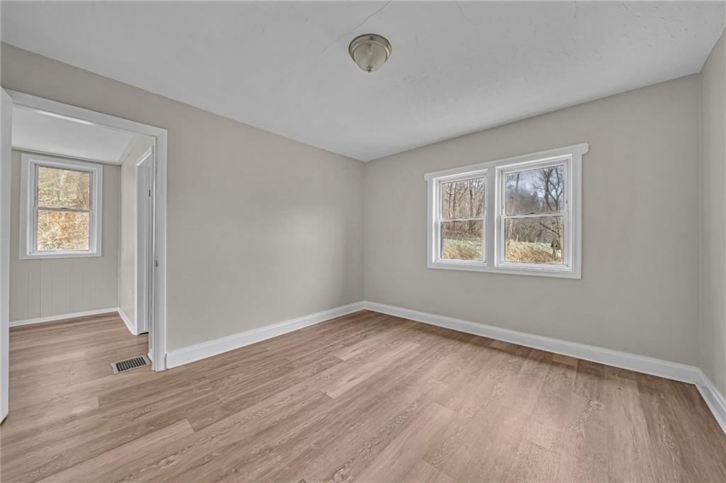 980 Crucible Road Rices Landing, PA 15357 - Photo 12 of 24 a view of an empty room with wooden floor and a window