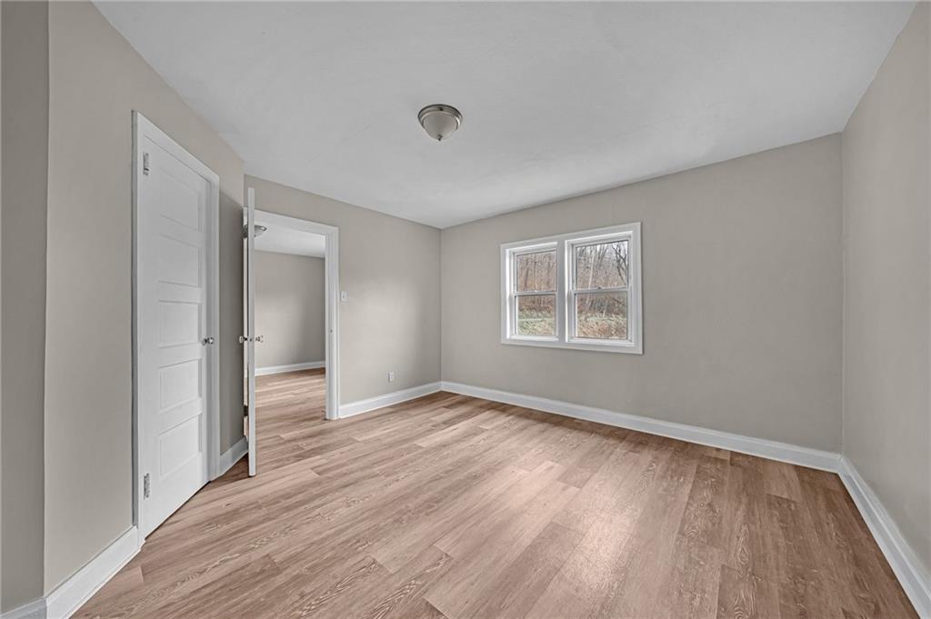 980 Crucible Road Rices Landing, PA 15357 - Photo 14 of 24 a view of an empty room with wooden floor and a window