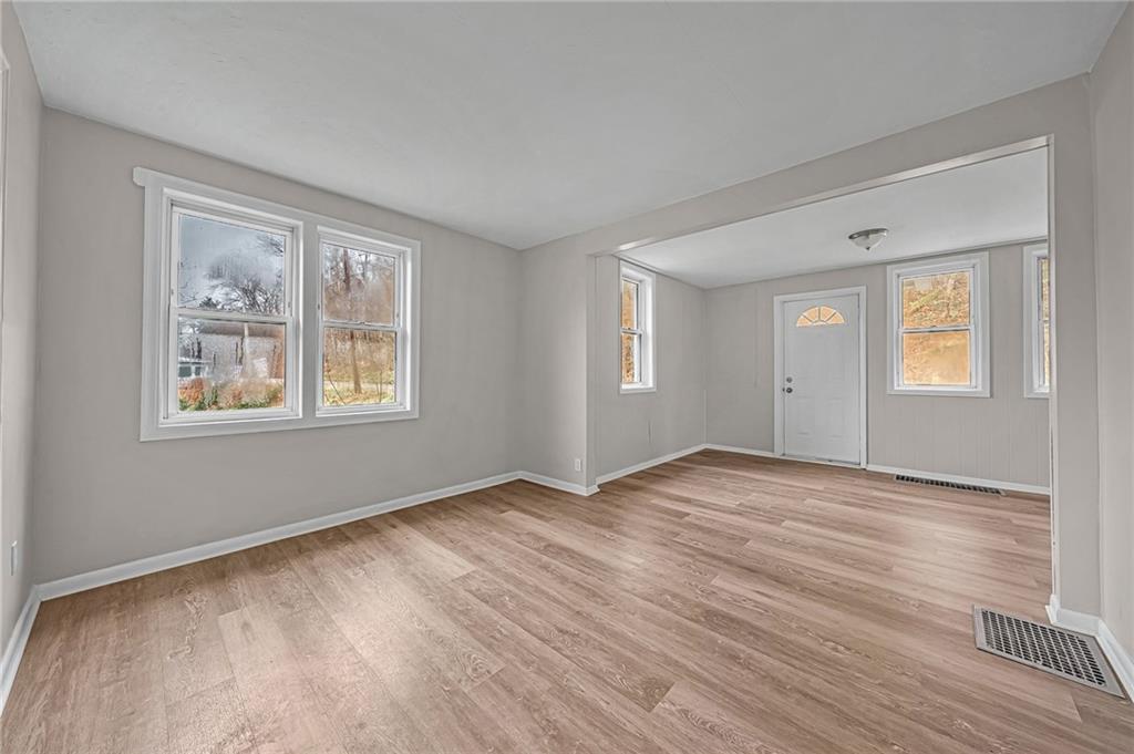 980 Crucible Road Rices Landing, PA 15357 - Photo 7 of 24 a view of an empty room with wooden floor and a window