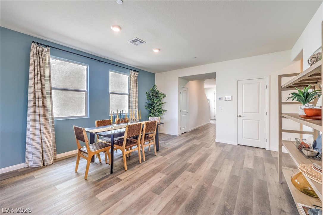 1017 Copper Robin Street Henderson, NV 89011 - Photo 7 of 43 Photo is representational only; actual home finishes may vary. Dining area featuring light wood-style flooring and baseboards
