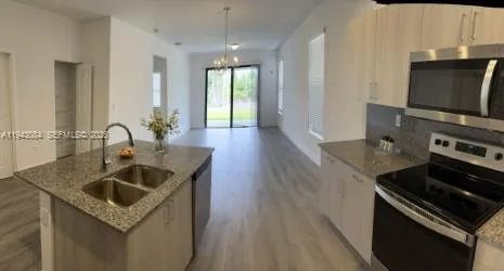 a kitchen with sink stove and refrigerator