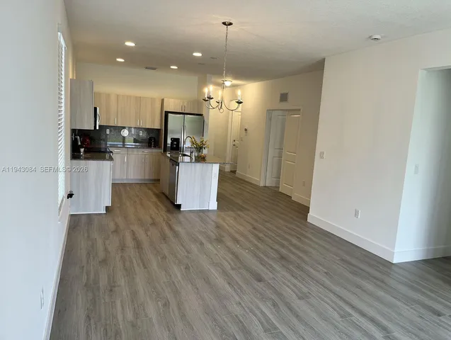 a view of kitchen with refrigerator microwave and wooden floor