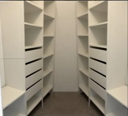 a view of walk in closet with empty racks