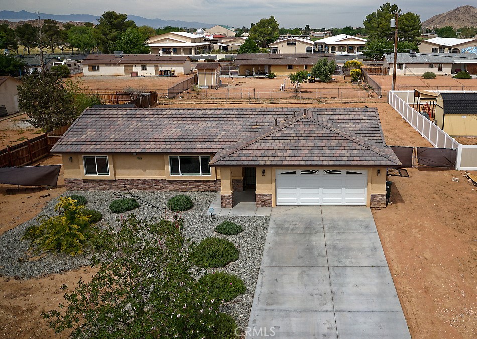 15440 Washoan Road Apple Valley, CA 92307 - Photo 1 of 1 an aerial view of a house with yard and trees in the background