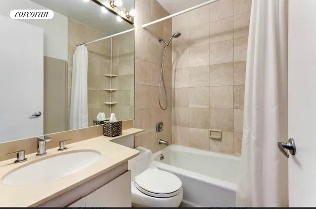 a bathroom with a bathtub shower sink vanity mirror and toilet