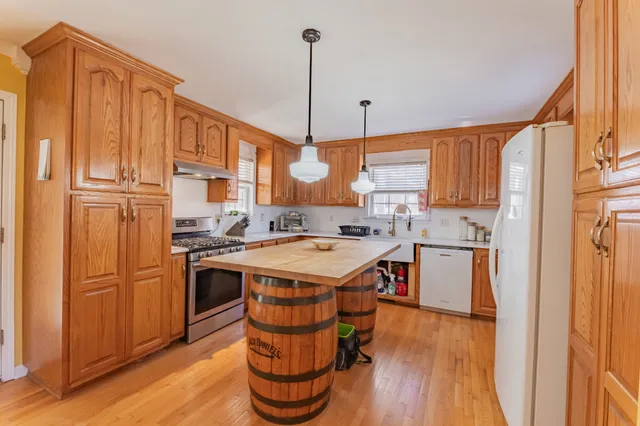 a kitchen with stainless steel appliances granite countertop a refrigerator a stove and a wooden floors