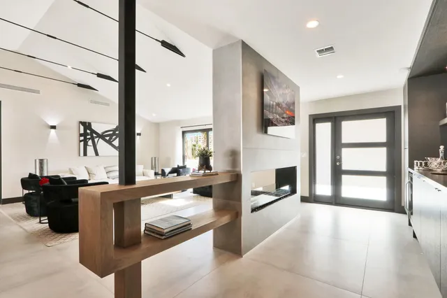 a large kitchen with a large counter top space a sink stainless steel appliances and cabinets