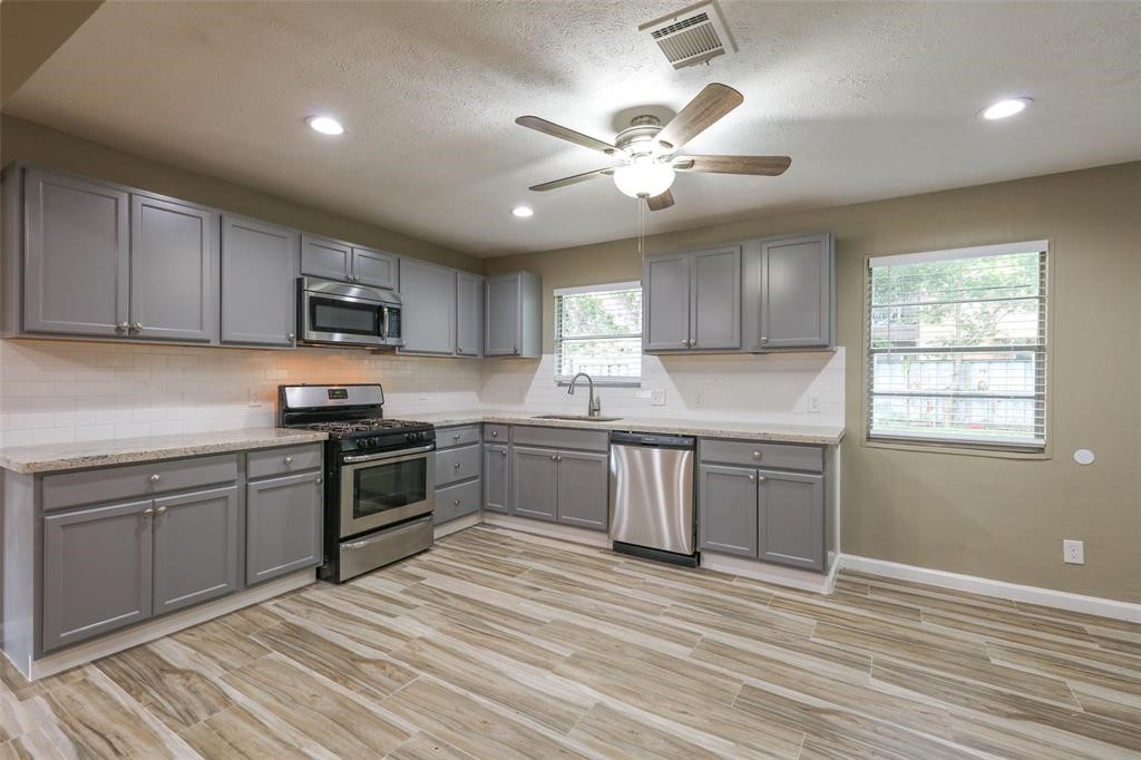 4139 Lumberdale Road Houston, TX 77092 - Photo 13 of 31 a kitchen with granite countertop a stove cabinets and wooden floor