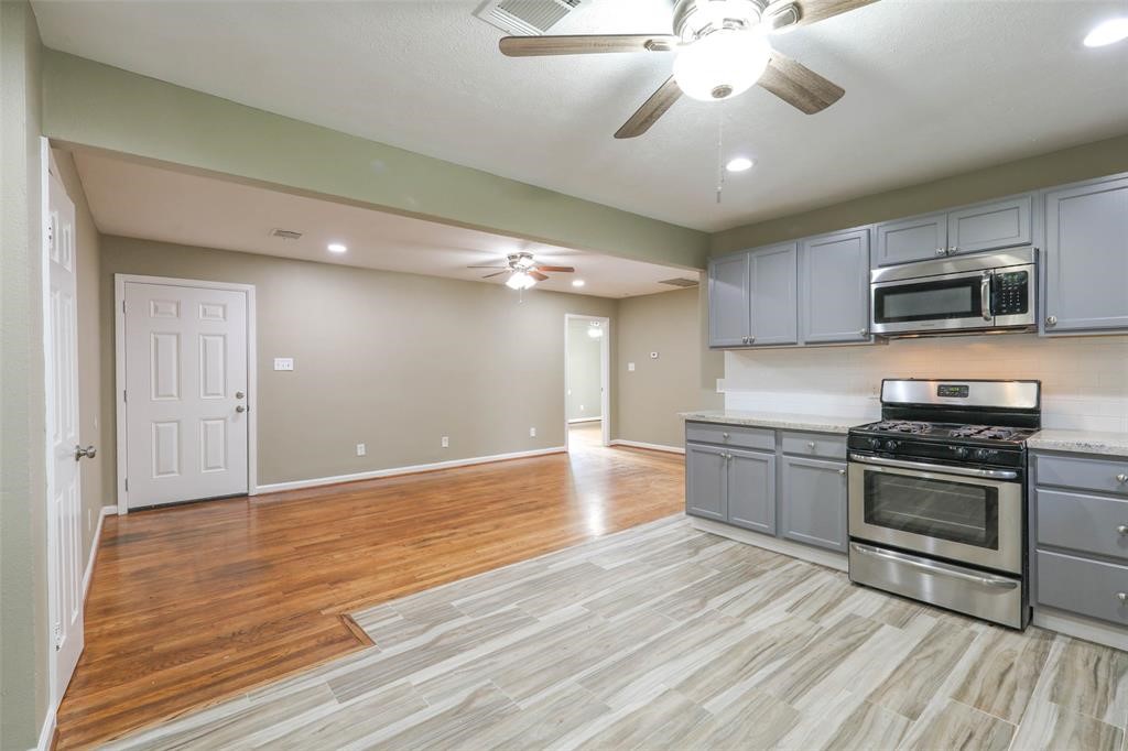 4139 Lumberdale Road Houston, TX 77092 - Photo 14 of 31 a kitchen with stainless steel appliances granite countertop a stove and a microwave