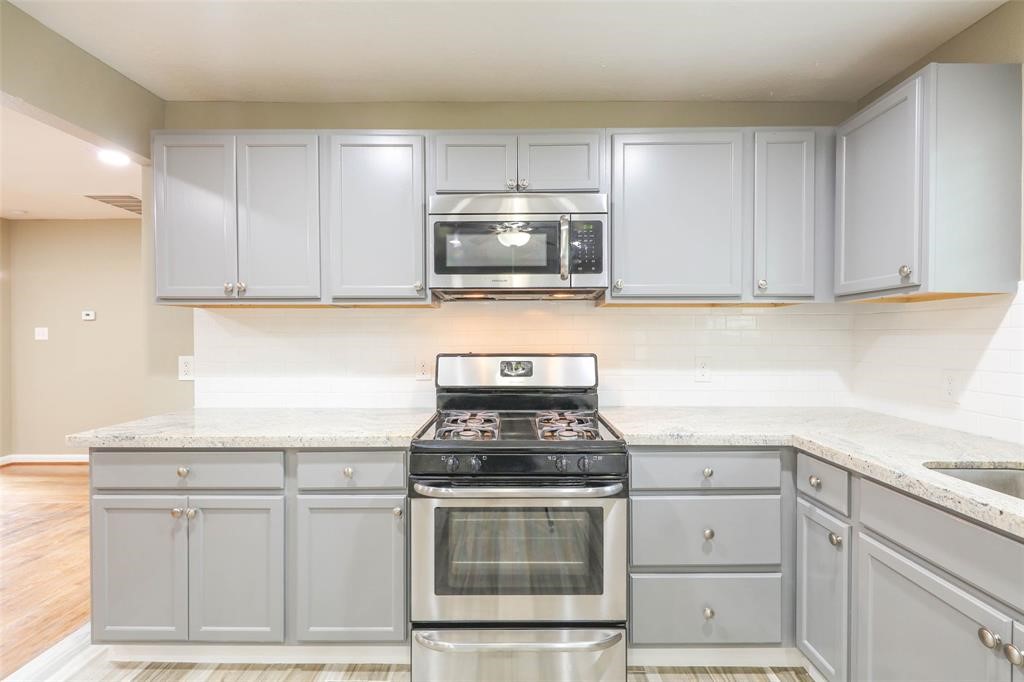 4139 Lumberdale Road Houston, TX 77092 - Photo 18 of 31 a kitchen with white cabinets stainless steel appliances and sink