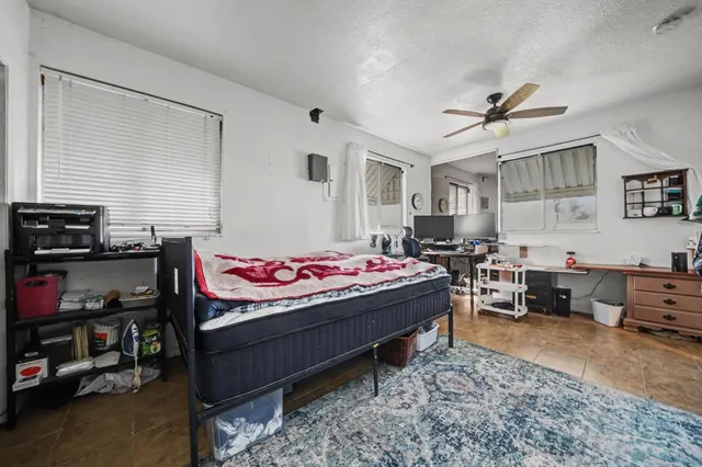 a view of an empty room with fireplace and windows