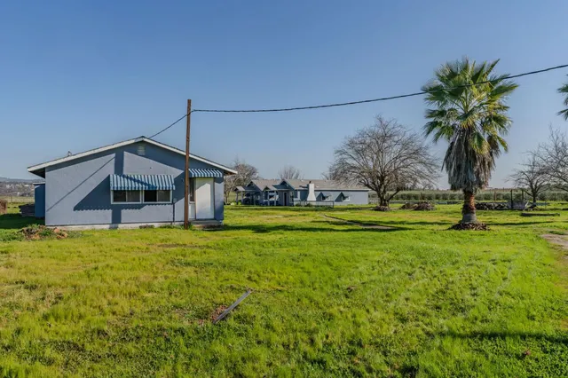 a view of a house with backyard and garden