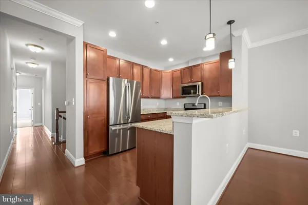 a kitchen with stainless steel appliances granite countertop a refrigerator microwave and stove