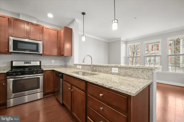 a kitchen with granite countertop wooden cabinets stainless steel appliances and a window