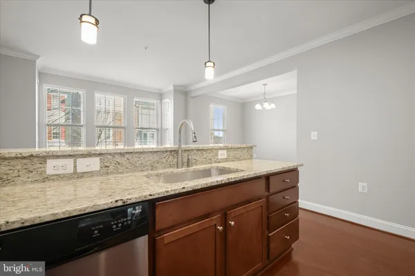 a kitchen with granite countertop kitchen island a sink appliances and a counter top space