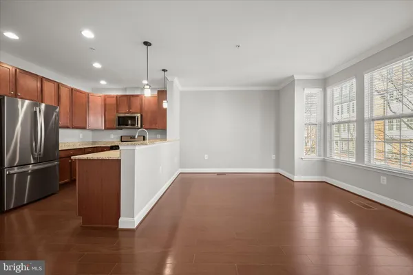 a kitchen with a refrigerator a stove top oven a sink and a potted plant