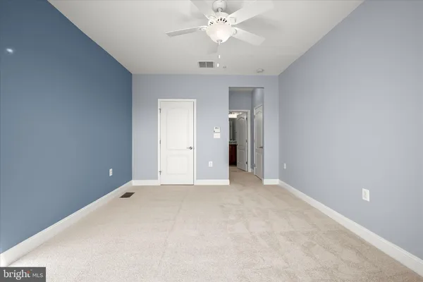 a view of an empty room with a ceiling fan