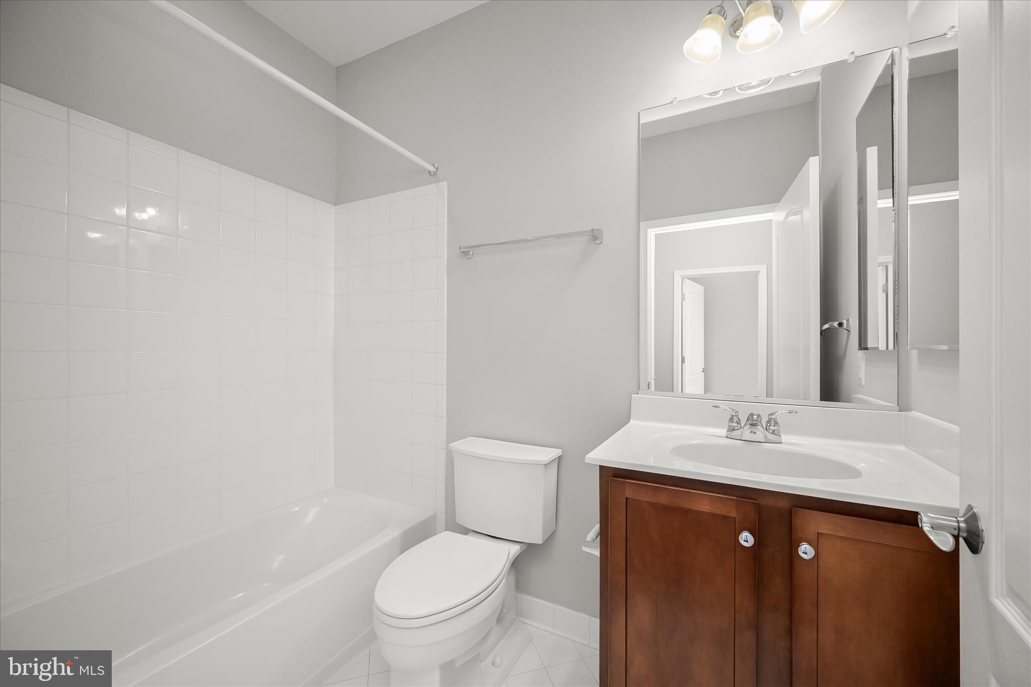 11246-1 Chase Street, Unit 141 Fulton, MD 20759 - Photo 36 of 38 a bathroom with a sink a toilet and a mirror