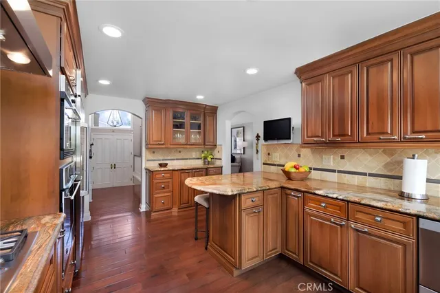a kitchen with stainless steel appliances granite countertop a sink stove and cabinets