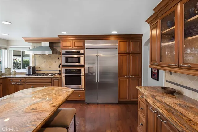 a dining room with wooden floor a chandelier a wooden table and chairs