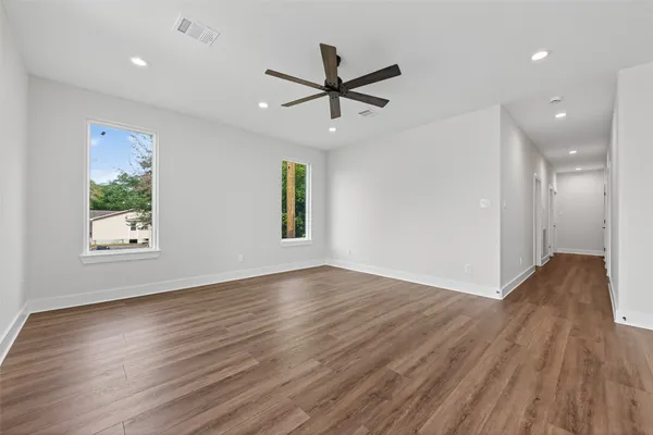 a view of a livingroom with a window wooden floor and a ceiling fan