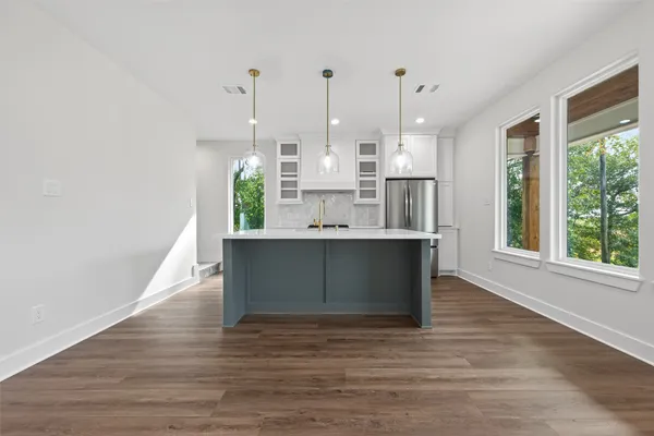 a view of kitchen with kitchen island and stainless steel appliances