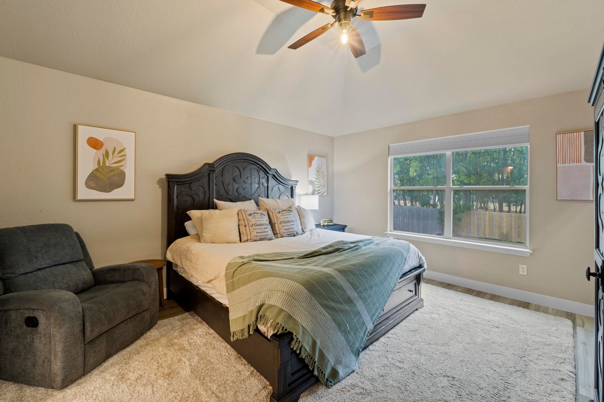 1020 Portchester Castle Path Pflugerville, TX 78660 - Photo 17 of 29 The primary bedroom is roomy with a high ceiling, a ceiling fan, vinyl plank flooring, and a backyard view.
