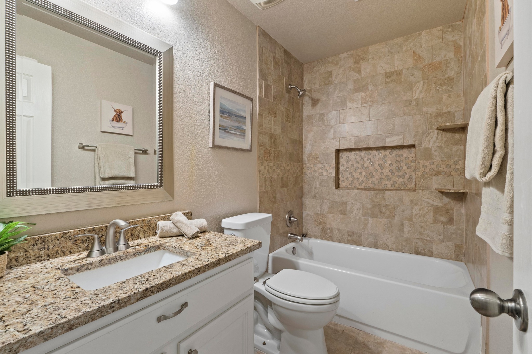 1020 Portchester Castle Path Pflugerville, TX 78660 - Photo 22 of 29 A lovely full bathroom with a framed mirror, granite countertops, tile flooring, and a bathtub/shower combo.