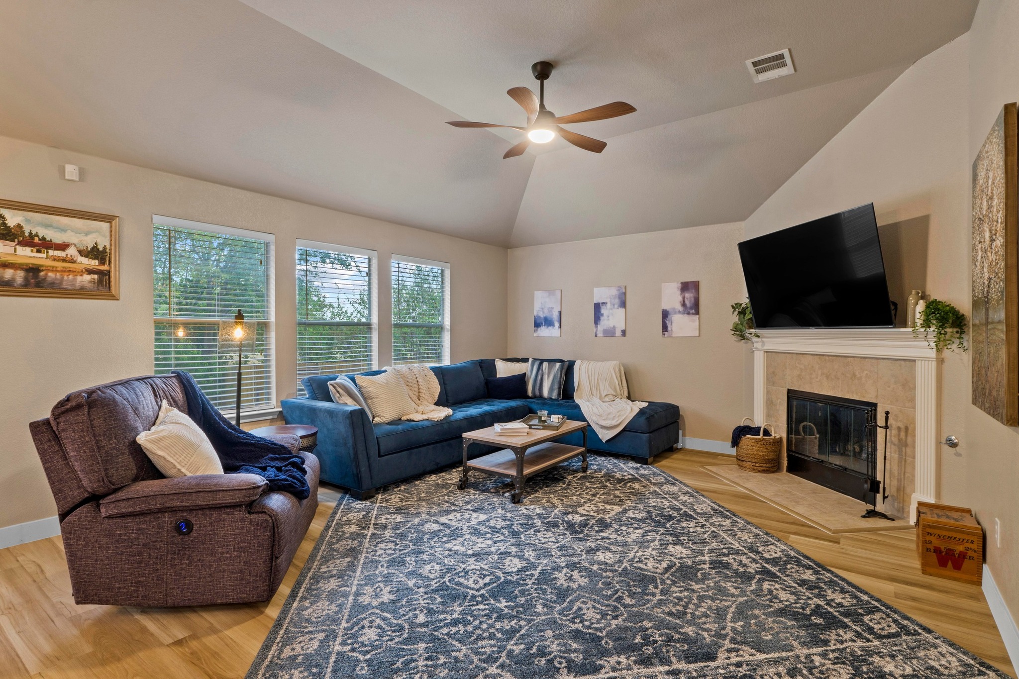 1020 Portchester Castle Path Pflugerville, TX 78660 - Photo 3 of 29 A spacious living room with a high ceiling, a ceiling fan, great natural light, and a cozy gas log fireplace.