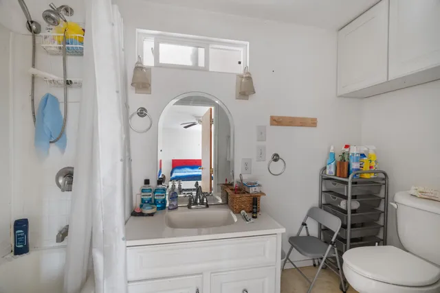 a bathroom with a toilet sink and shower curtain
