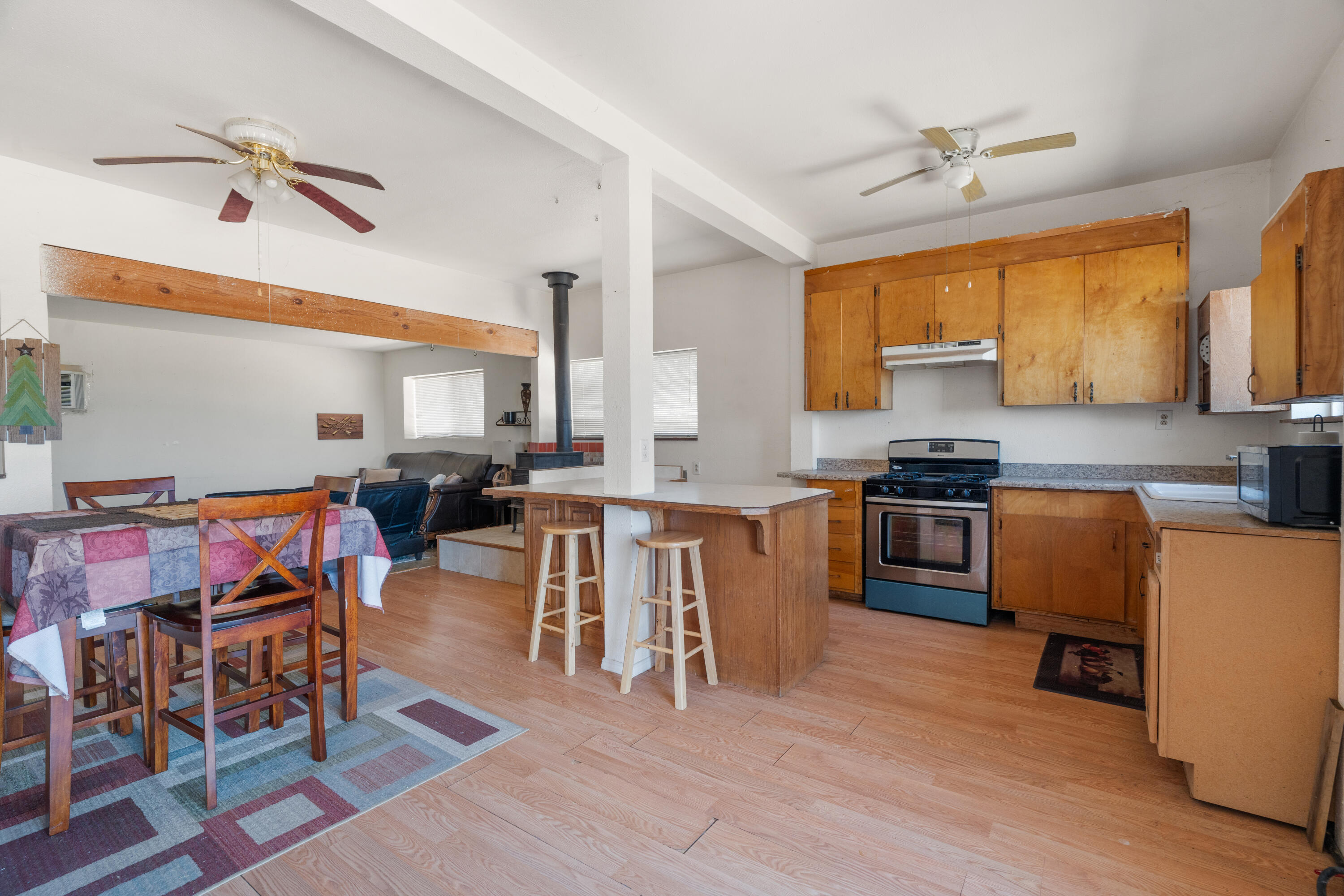 16720 Blue Oak Road Cottonwood, CA 96022 - Photo 6 of 35 a kitchen with stainless steel appliances granite countertop a stove top oven a sink a dining table and chairs with wooden floor