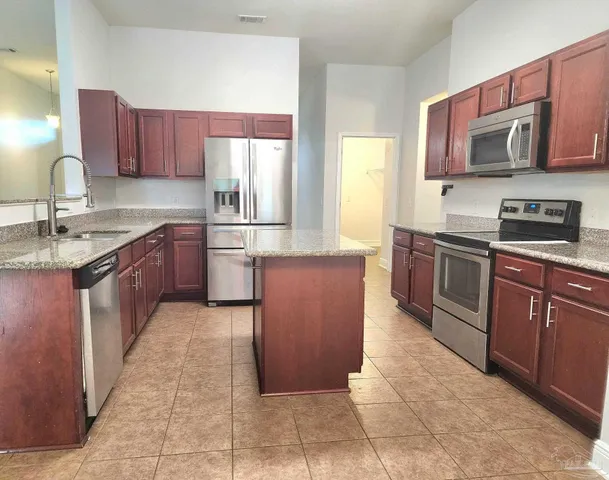 a kitchen with stainless steel appliances granite countertop a stove microwave and sink