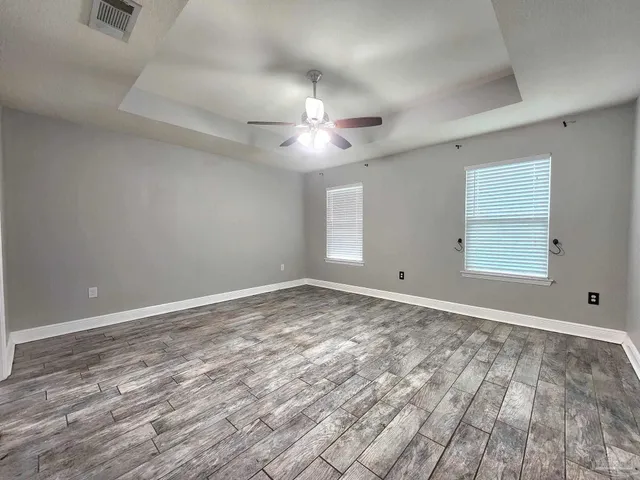 a view of an empty room and chandelier fan