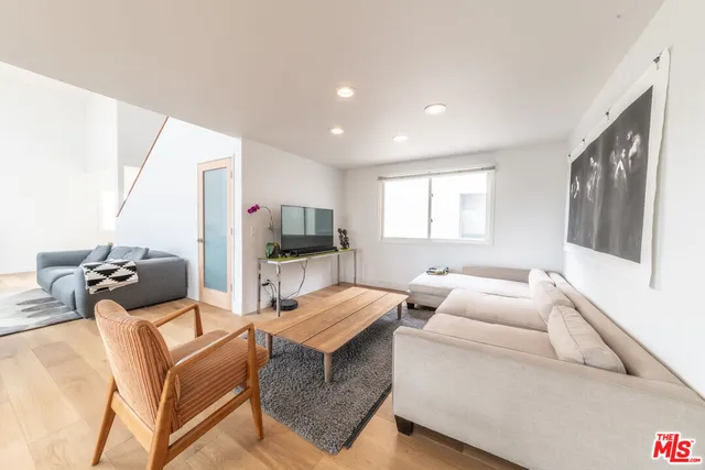 a spacious bedroom with a bed a table and flat screen tv