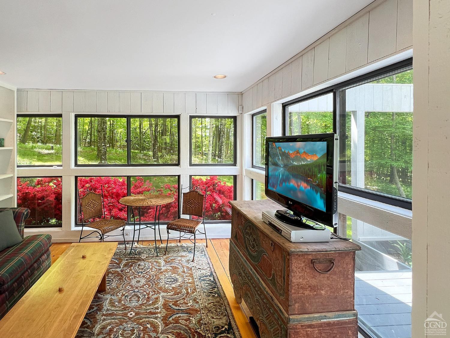 208 Cambridge Road Copake, NY 12529 - Photo 22 of 36 a living room with furniture a flat screen tv and floor to ceiling window