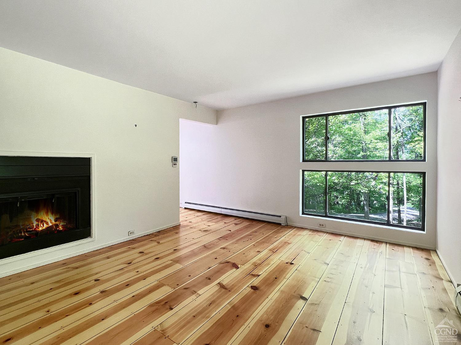 208 Cambridge Road Copake, NY 12529 - Photo 31 of 36 a view of an empty room with wooden floor fireplace and a window