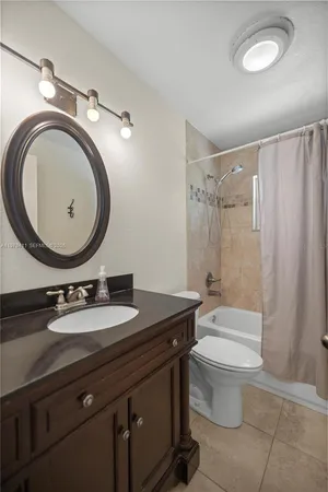 a bathroom with a granite countertop toilet a sink and a mirror