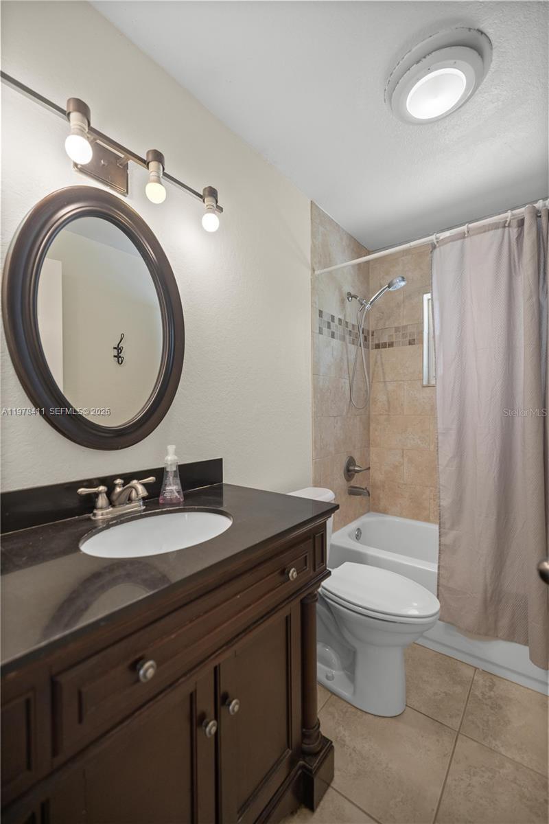 1699 Southwest 80th Street Ocala, FL 34476 - Photo 18 of 47 a bathroom with a granite countertop toilet a sink and a mirror