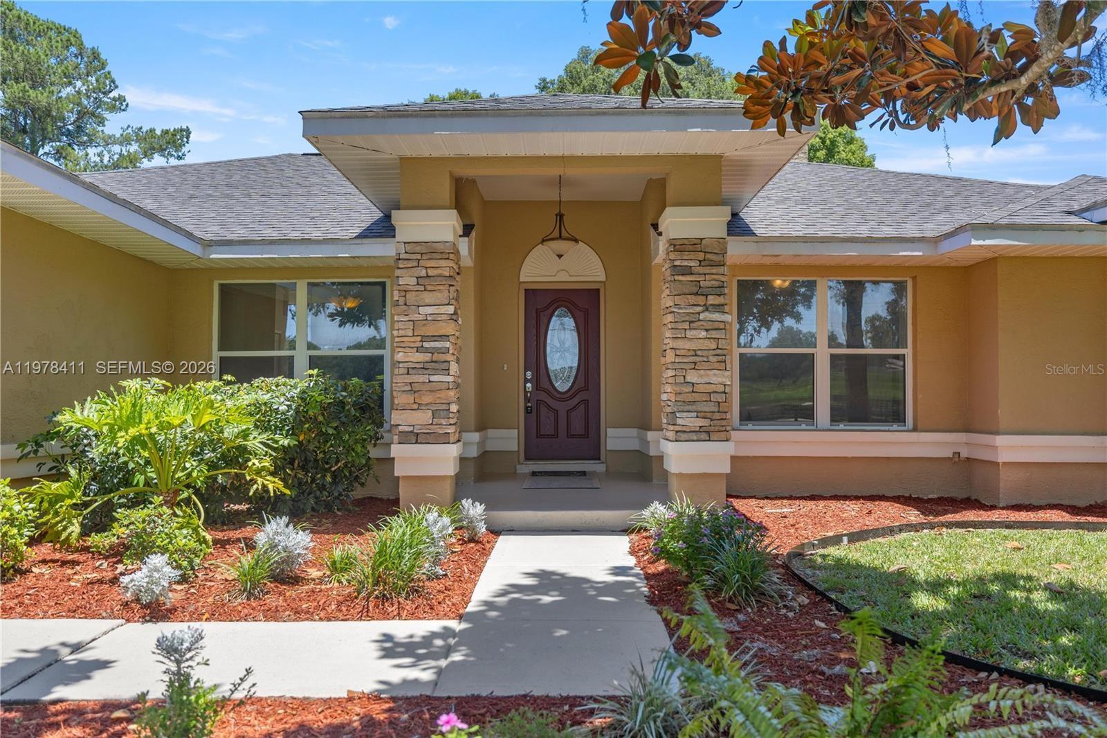 1699 Southwest 80th Street Ocala, FL 34476 - Photo 2 of 47 a front view of a house with garden