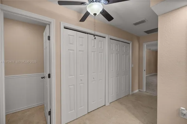 a view of empty room with chandelier fan