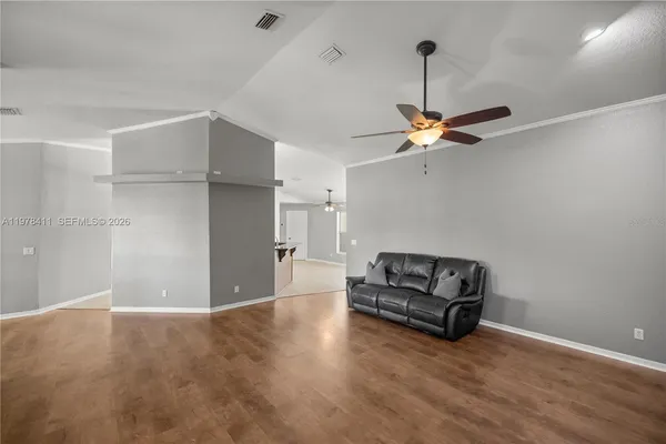 a view of an empty room with a fireplace and a chandelier fan