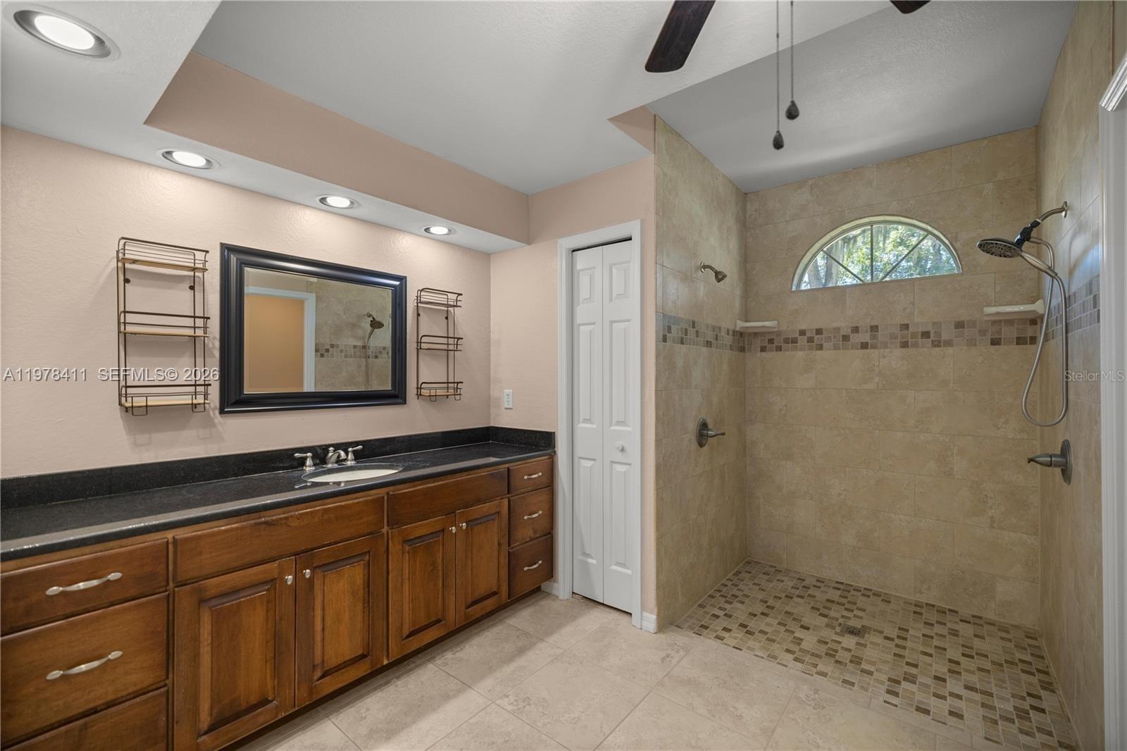 1699 Southwest 80th Street Ocala, FL 34476 - Photo 30 of 47 a bathroom with a sink a mirror and a shower