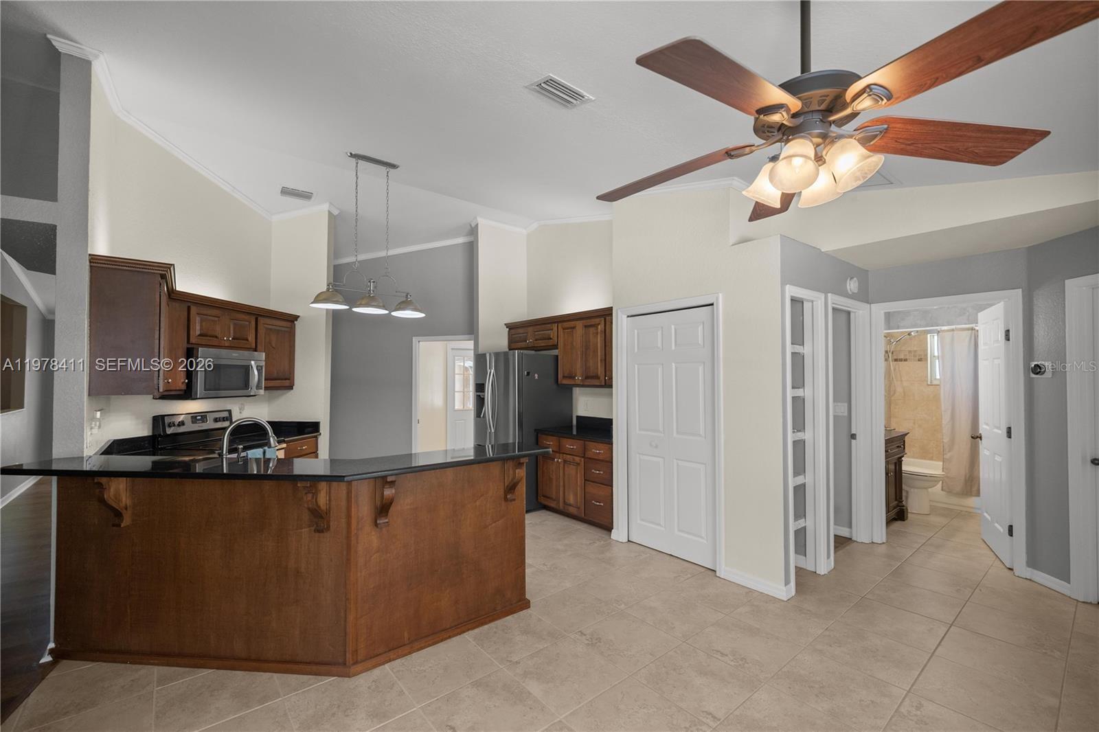 1699 Southwest 80th Street Ocala, FL 34476 - Photo 34 of 47 a kitchen with stainless steel appliances kitchen island granite countertop a refrigerator and a sink