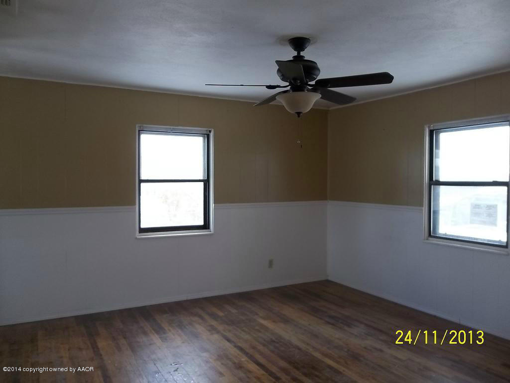 4604 Cline Road Amarillo, TX 79110 - Photo 3 of 7 an empty room with a window and a fan
