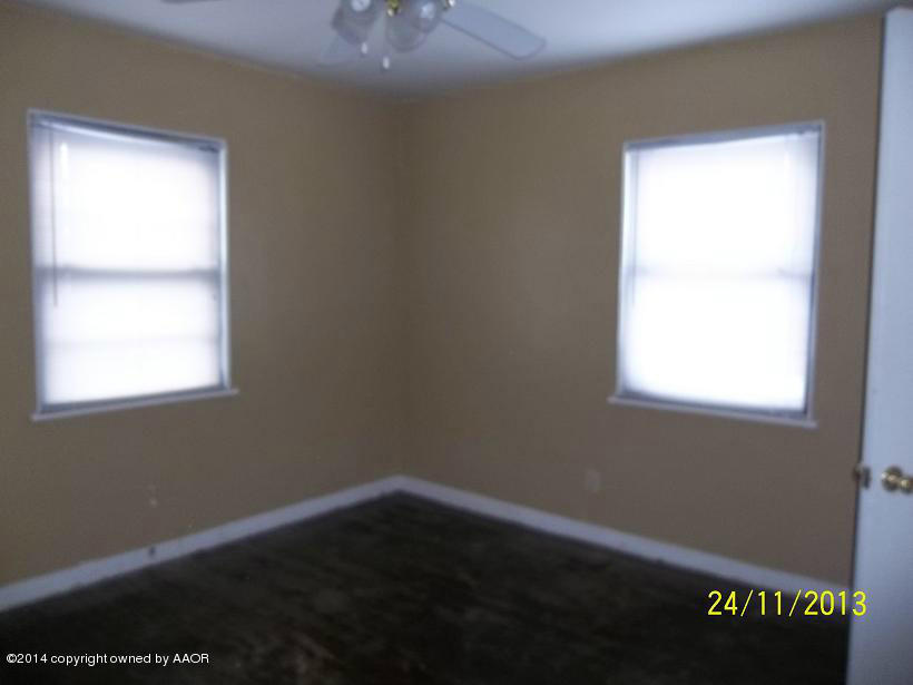 4604 Cline Road Amarillo, TX 79110 - Photo 5 of 7 a view of an empty room with wooden floor and a window