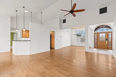 a kitchen with stainless steel appliances granite countertop a sink a refrigerator a stove and a refrigerator with wooden floor