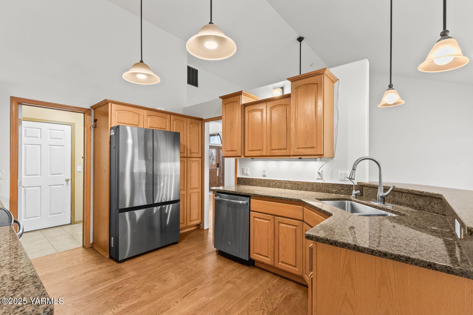 10709 Summitview Road Yakima, WA 98908 - Photo 15 of 32 a kitchen with stainless steel appliances granite countertop a sink a refrigerator a stove and a refrigerator with wooden floor