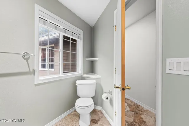a bathroom with a toilet and a window