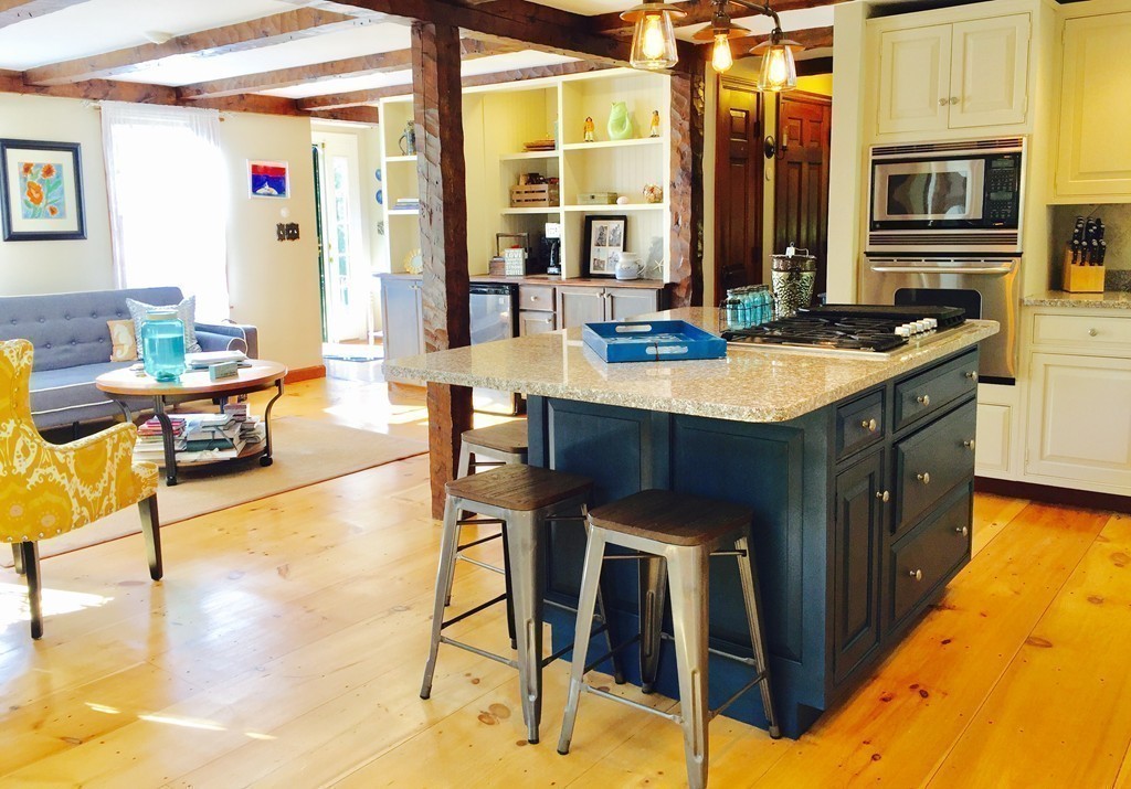 10 Wamsutta Road Scituate, MA 02066 - Photo 18 of 30 a kitchen with stainless steel appliances kitchen island granite countertop a table chairs in it and wooden floor